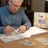 Man collecting and organizing stamps in stamp collecting binder